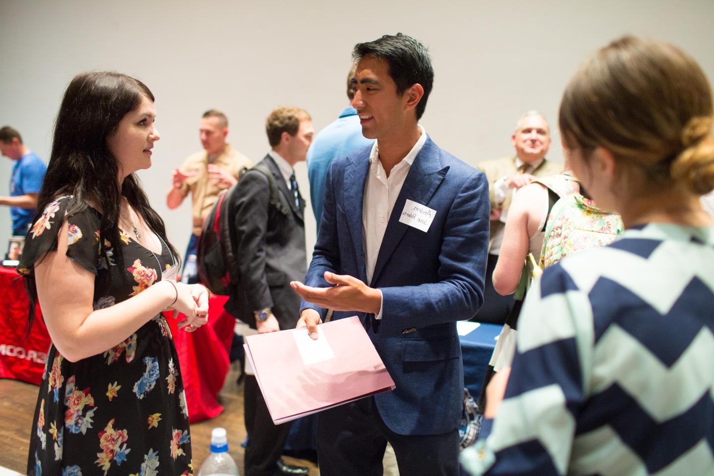 Students talking to prospective employers at the Career Fair in person