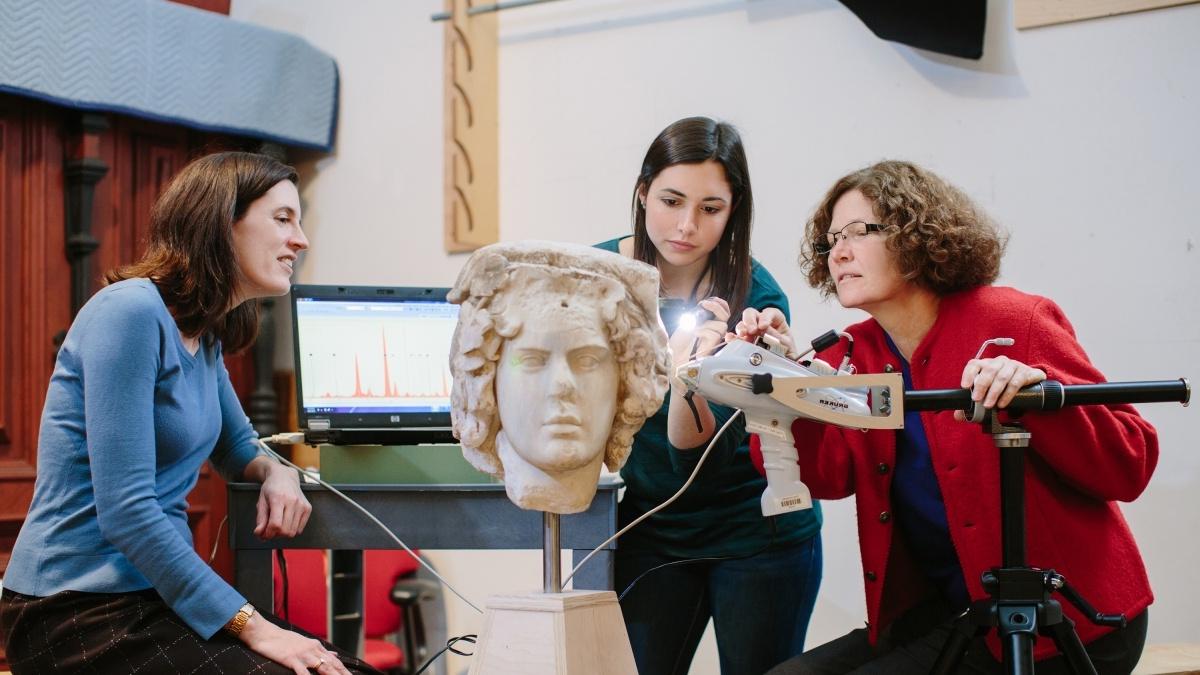 Professor and students looking at Greek sculpture