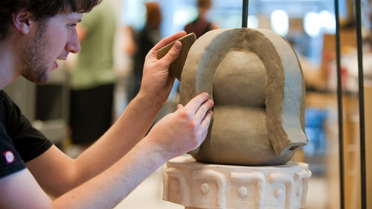 male student working on a sculpture