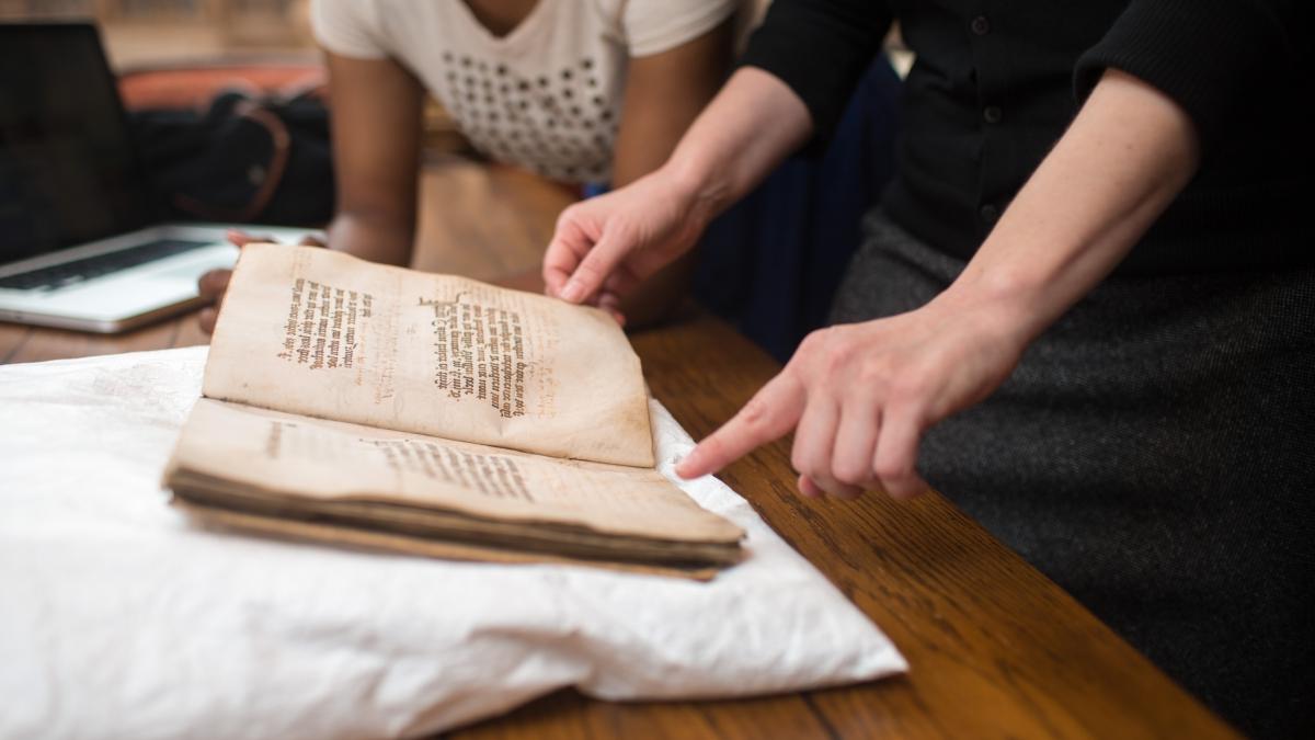 Student handles age-worn book in the 科茨库 特别馆藏及档案.